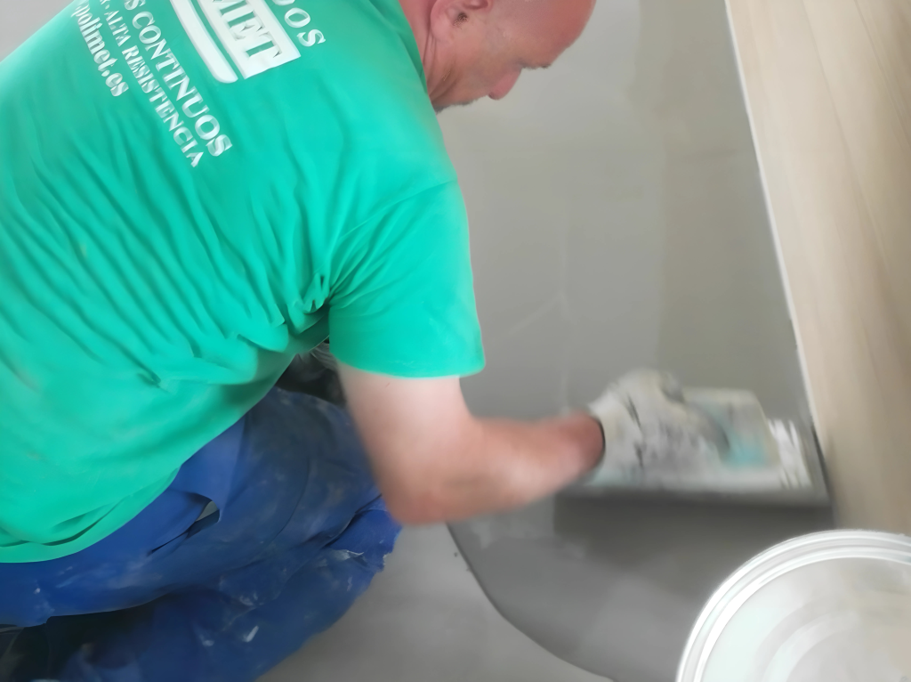Hombre aplicando microcemento para la decoración de suelos y paredes