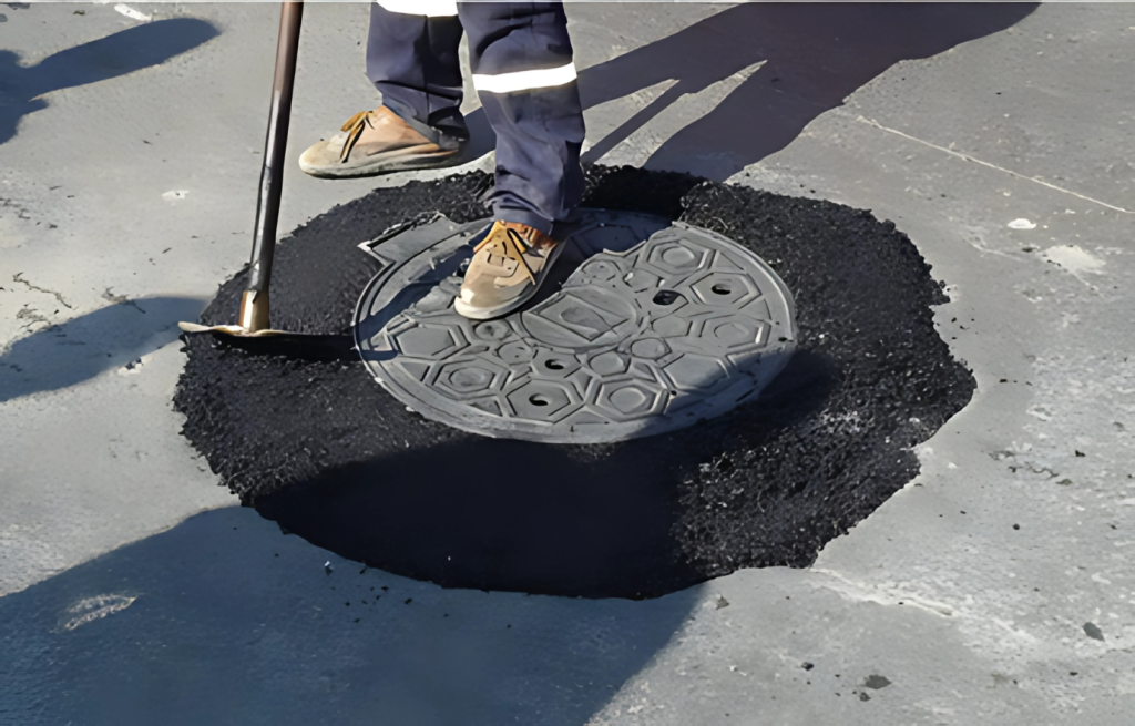 Alcantarilla con asfalto reciente alrededor