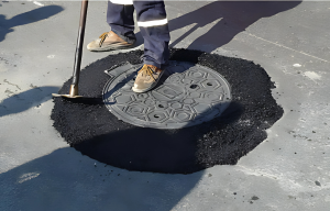 Alcantarilla con asfalto reciente alrededor